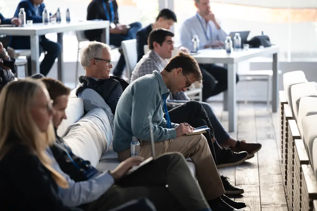Attendees taking notes in the glass tent in natural light